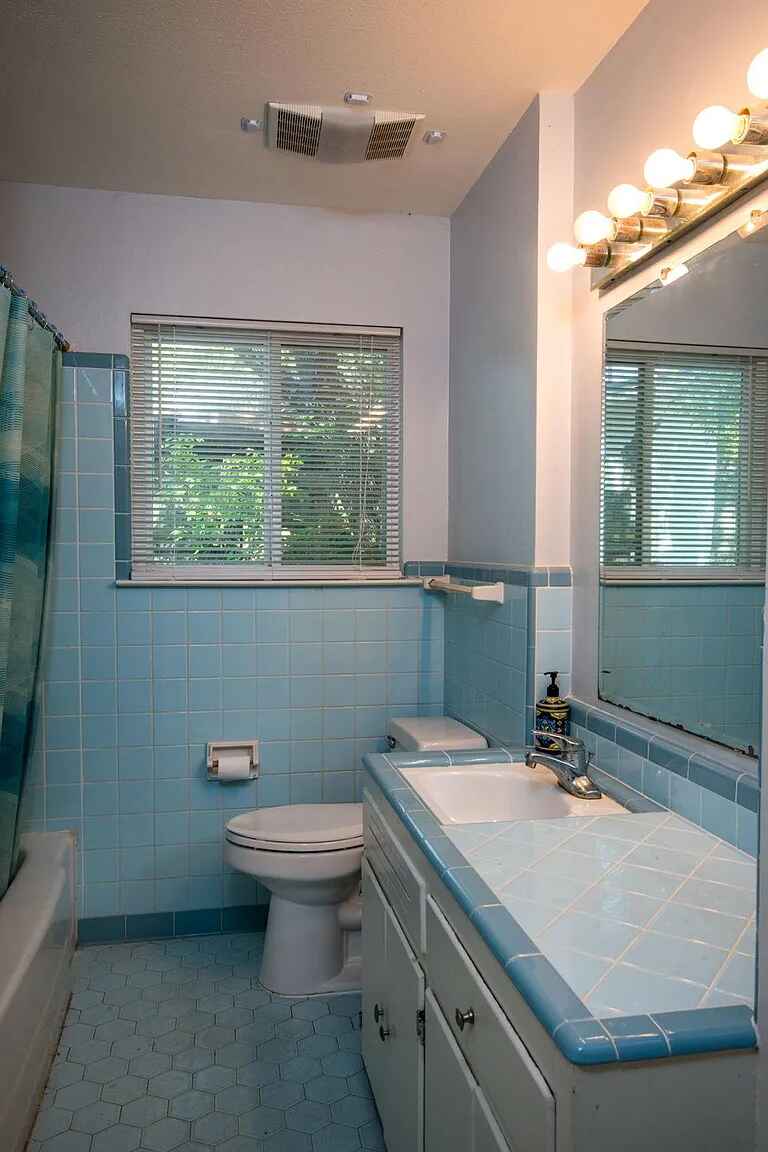 1207 Fieldcrest Drive Austin, TX 78704 - Photo 11 of 13 a bathroom with a granite countertop sink a large mirror and a toilet