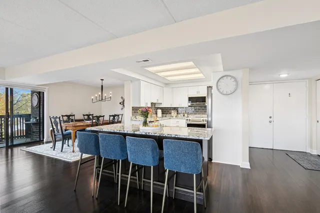 a dining room with wooden floor a glass table and chairs