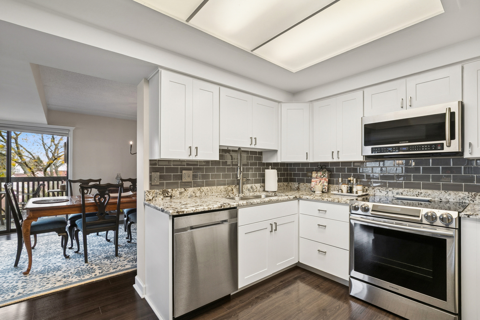 920 Vose Drive, Unit 202 Gurnee, IL 60031 - Photo 7 of 21 a kitchen with a sink stove and white cabinets