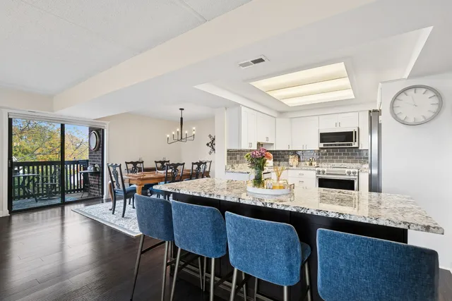 a kitchen with a dining table chairs and stove
