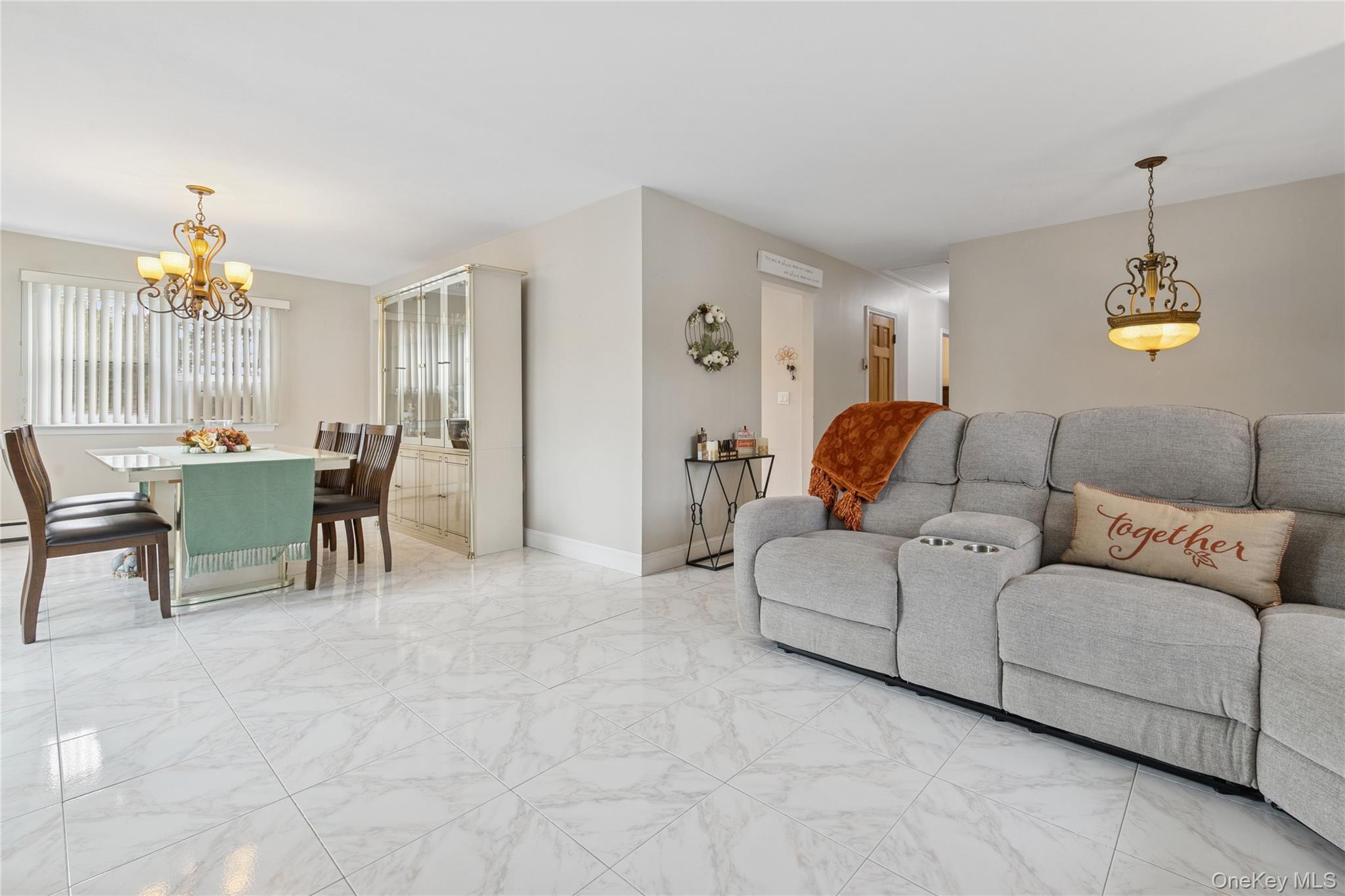 308 Browns Road Nesconset, NY 11767 - Photo 10 of 34 a living room with furniture a dining table and a chandelier