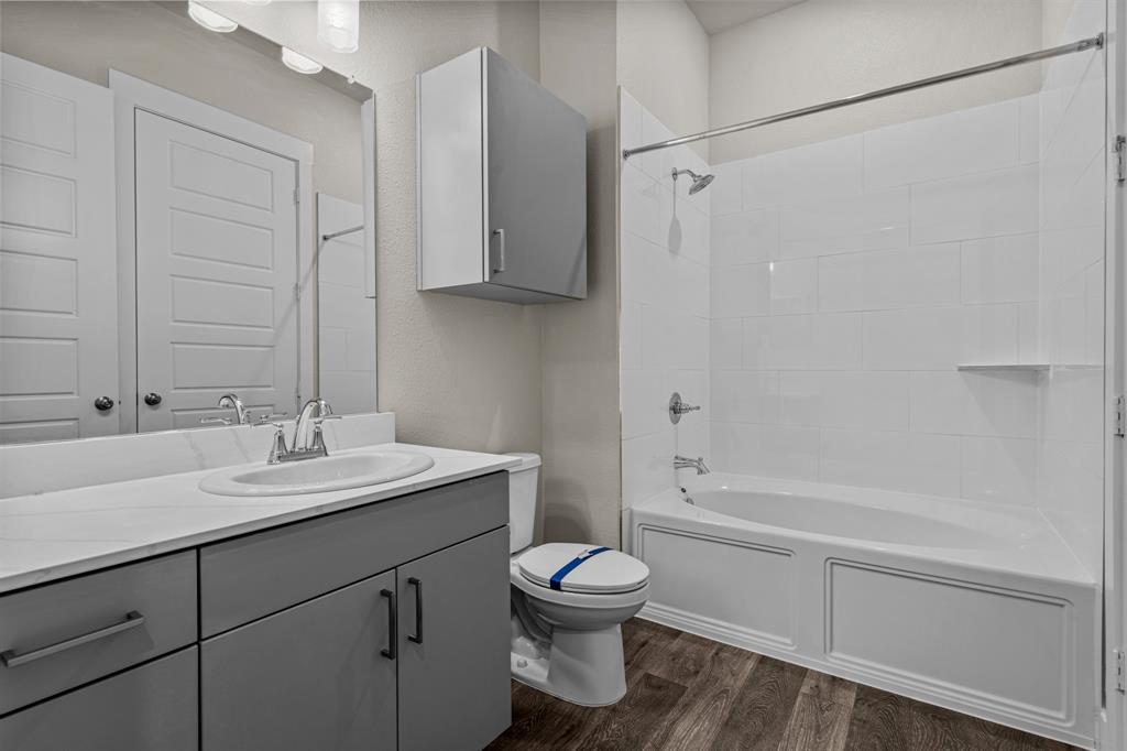 3282 Ganzer Road West, Unit 819B Denton, TX 76207 - Photo 11 of 40 a bathroom with a granite countertop sink toilet a mirror and shower