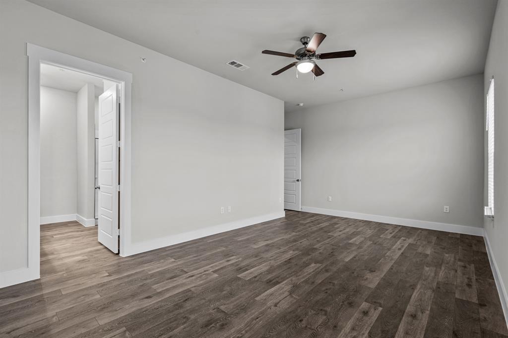 3282 Ganzer Road West, Unit 819B Denton, TX 76207 - Photo 23 of 40 an empty room with wooden floor ceiling fan and windows