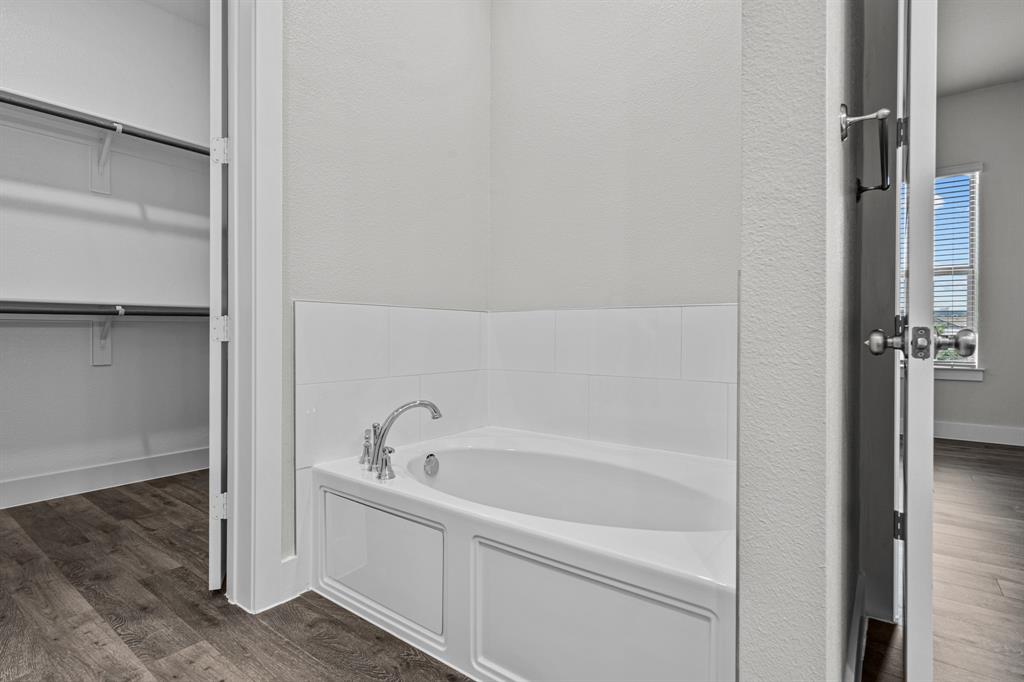 3282 Ganzer Road West, Unit 819B Denton, TX 76207 - Photo 27 of 40 a white bath tub sitting next to a shower