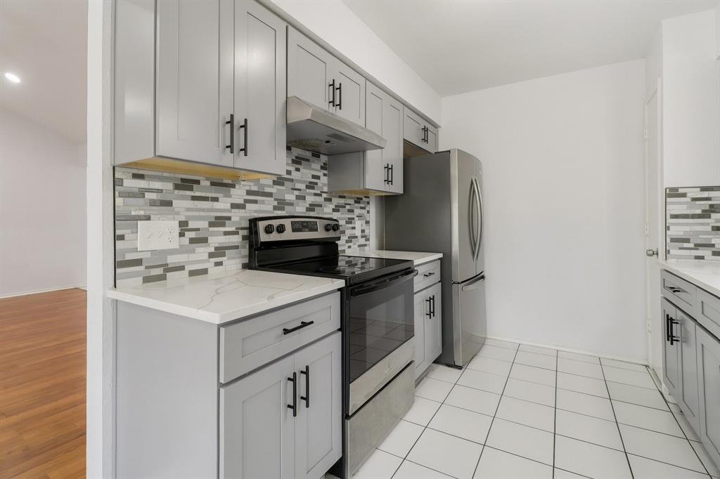 413 Chimney Rock Road Everman, TX 76140 - Photo 11 of 25 a kitchen with cabinets and steel appliances