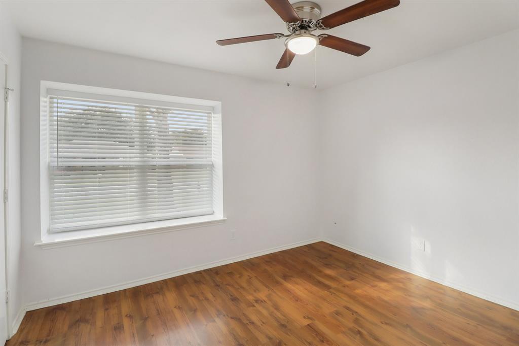 413 Chimney Rock Road Everman, TX 76140 - Photo 17 of 25 a view of an empty room with wooden floor and a window