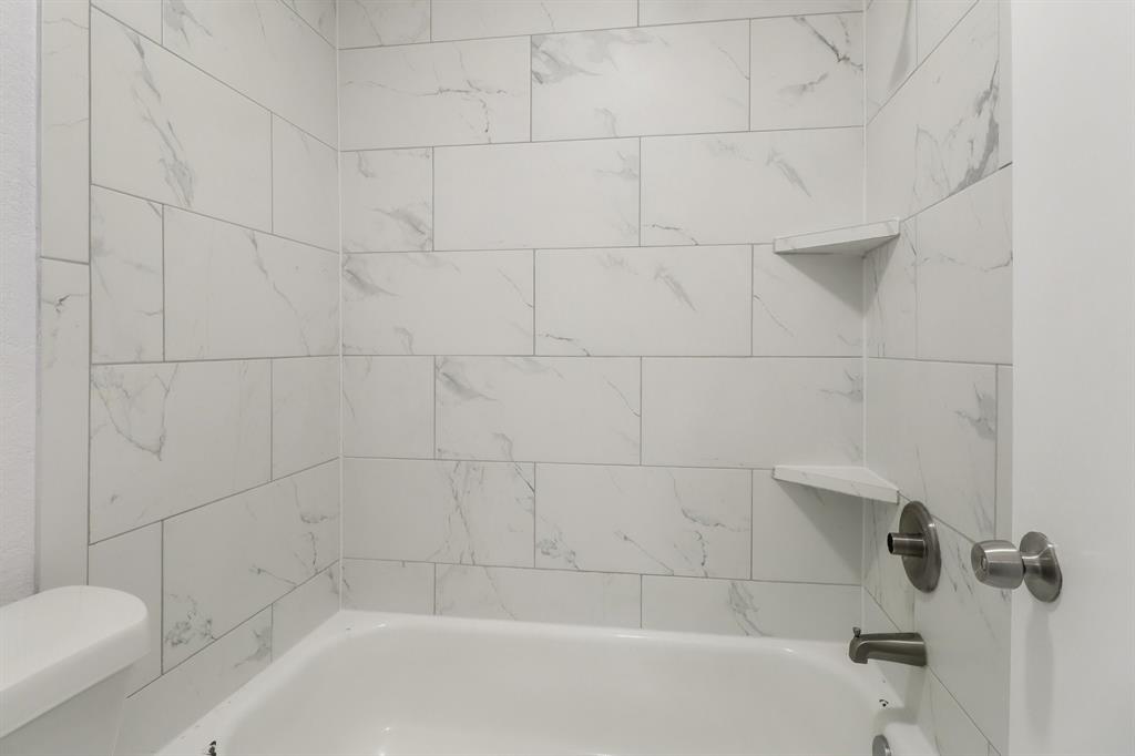 413 Chimney Rock Road Everman, TX 76140 - Photo 19 of 25 a bathroom with a bathtub and toilet