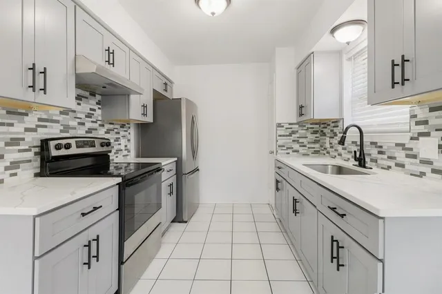 a kitchen with stainless steel appliances a sink stove and cabinets