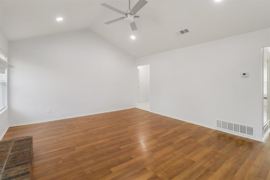 413 Chimney Rock Road Everman, TX 76140 - Photo 9 of 25 an empty room with wooden floor and fan