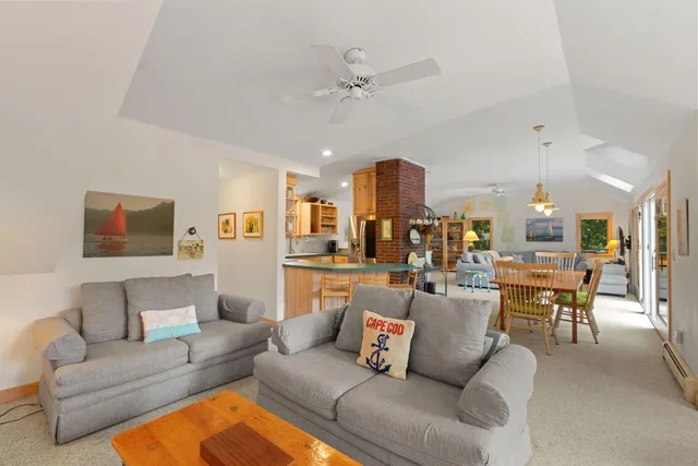 a living room with furniture kitchen view and a chandelier