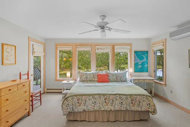 a bedroom with a bed and large windows