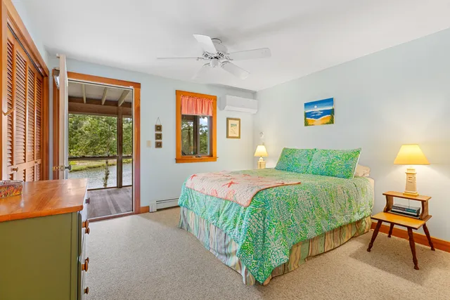 a bedroom with a bed and a dresser next to a window