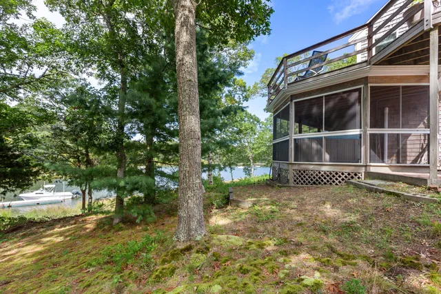 a view of a house with a large tree and a yard
