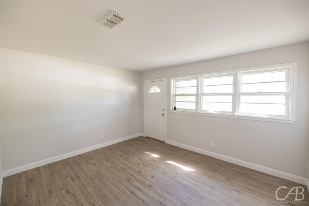 872 Forrest Avenue Abilene, TX 79603 - Photo 12 of 21 an empty room with wooden floor and windows