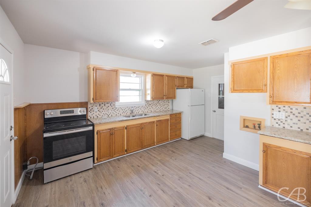 872 Forrest Avenue Abilene, TX 79603 - Photo 19 of 21 a kitchen with stainless steel appliances granite countertop a stove a sink and a refrigerator