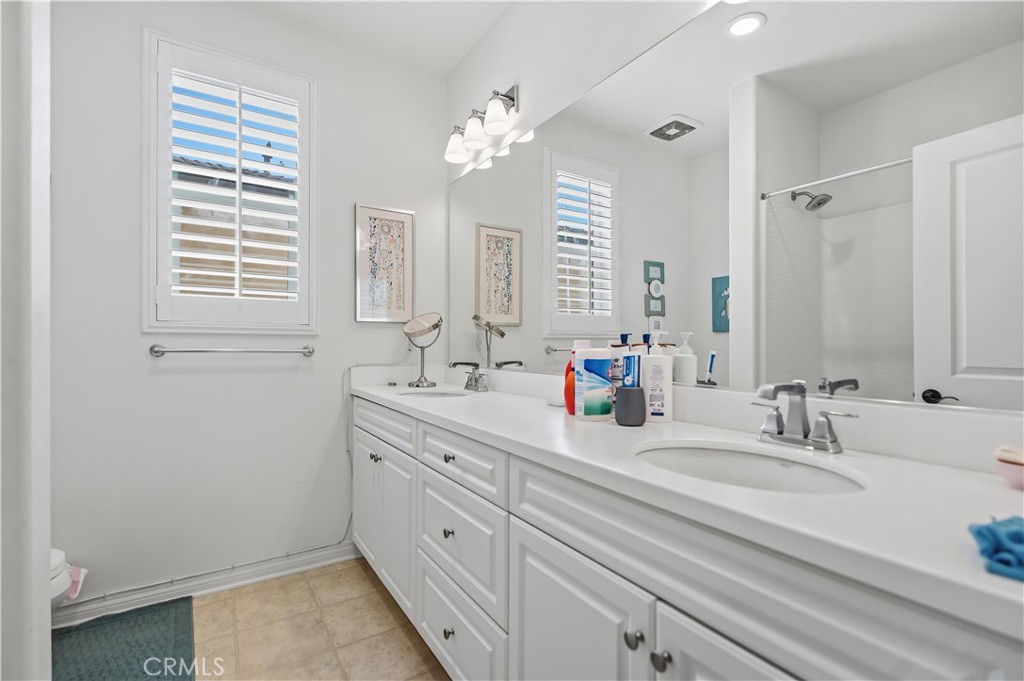 3380 Pine Ridge Loop Ontario, CA 91761 - Photo 26 of 37 a bathroom with double vanity sink a window and a mirror