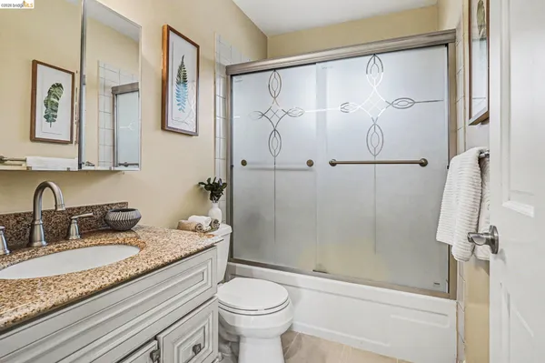 a bathroom with a granite countertop sink toilet and shower