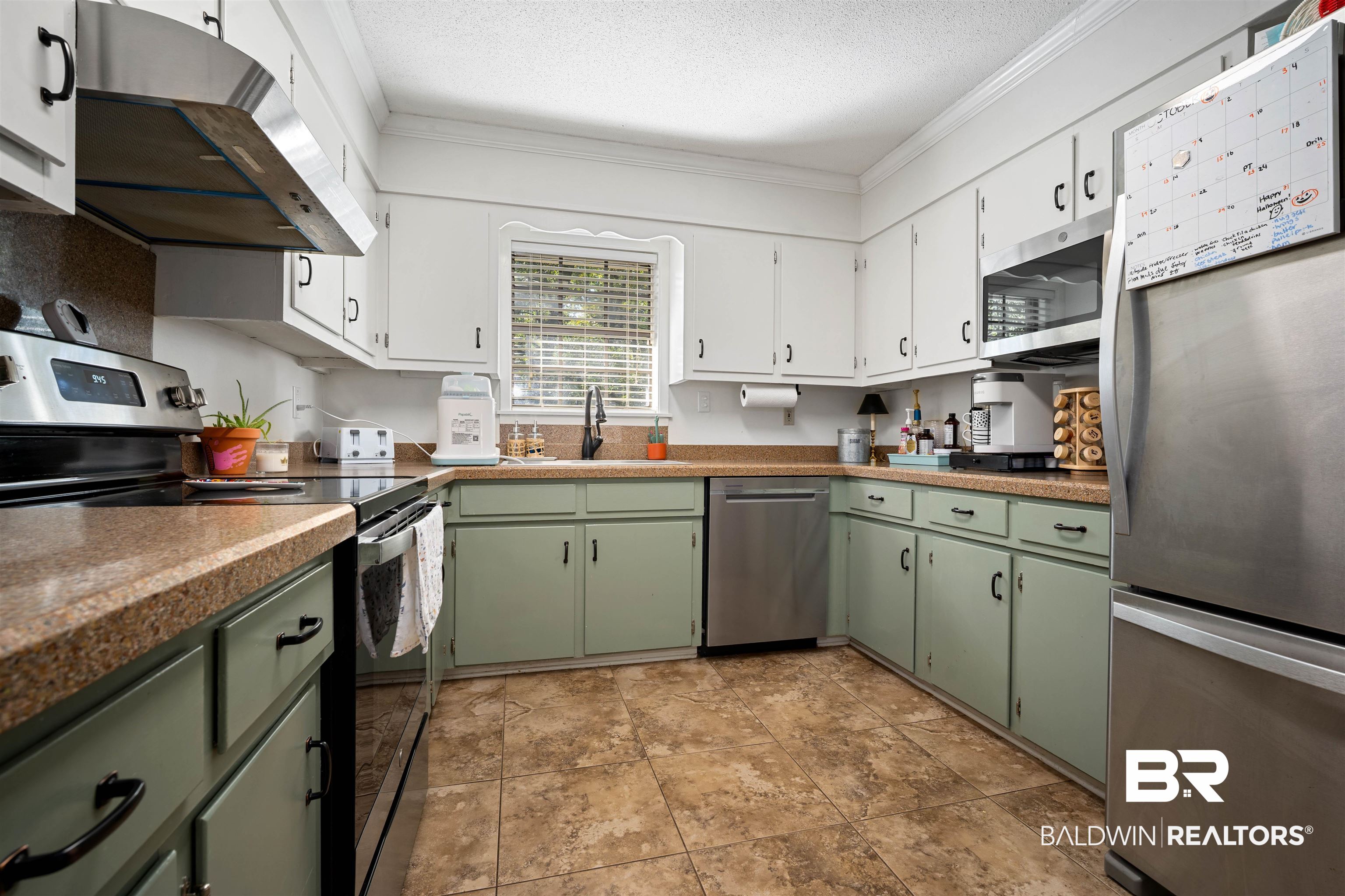 74 Caisson Trace Spanish Fort, AL 36527 - Photo 8 of 26 Kitchen with green cabinetry, appliances with stainless steel finishes, white cabinetry, under cabinet range hood, and crown molding