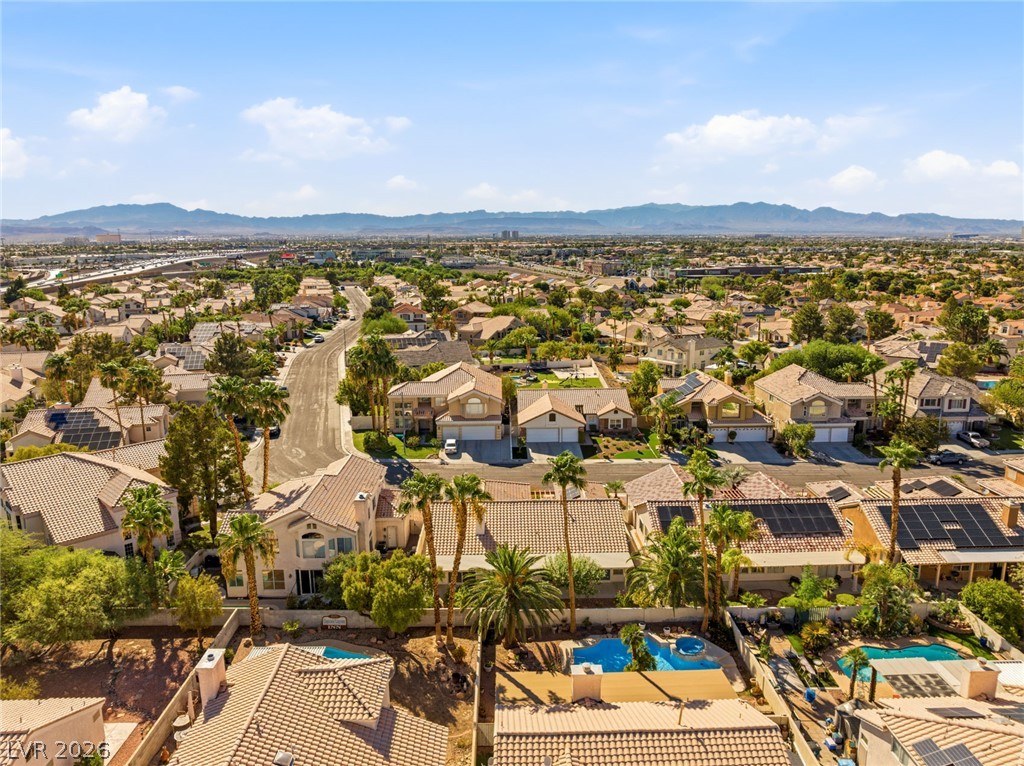 9034 Ridgepointe Way Henderson, NV 89074 - Photo 50 of 56 An aerial perspective showcases the surrounding neighborhood rooftops framed by distant mountain ranges.