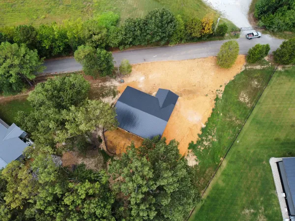 an aerial view of a house with a yard and lake view