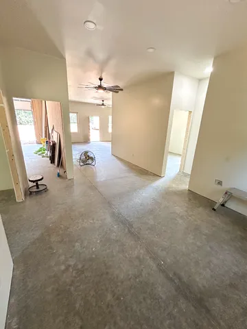 an empty room with a window and a fan