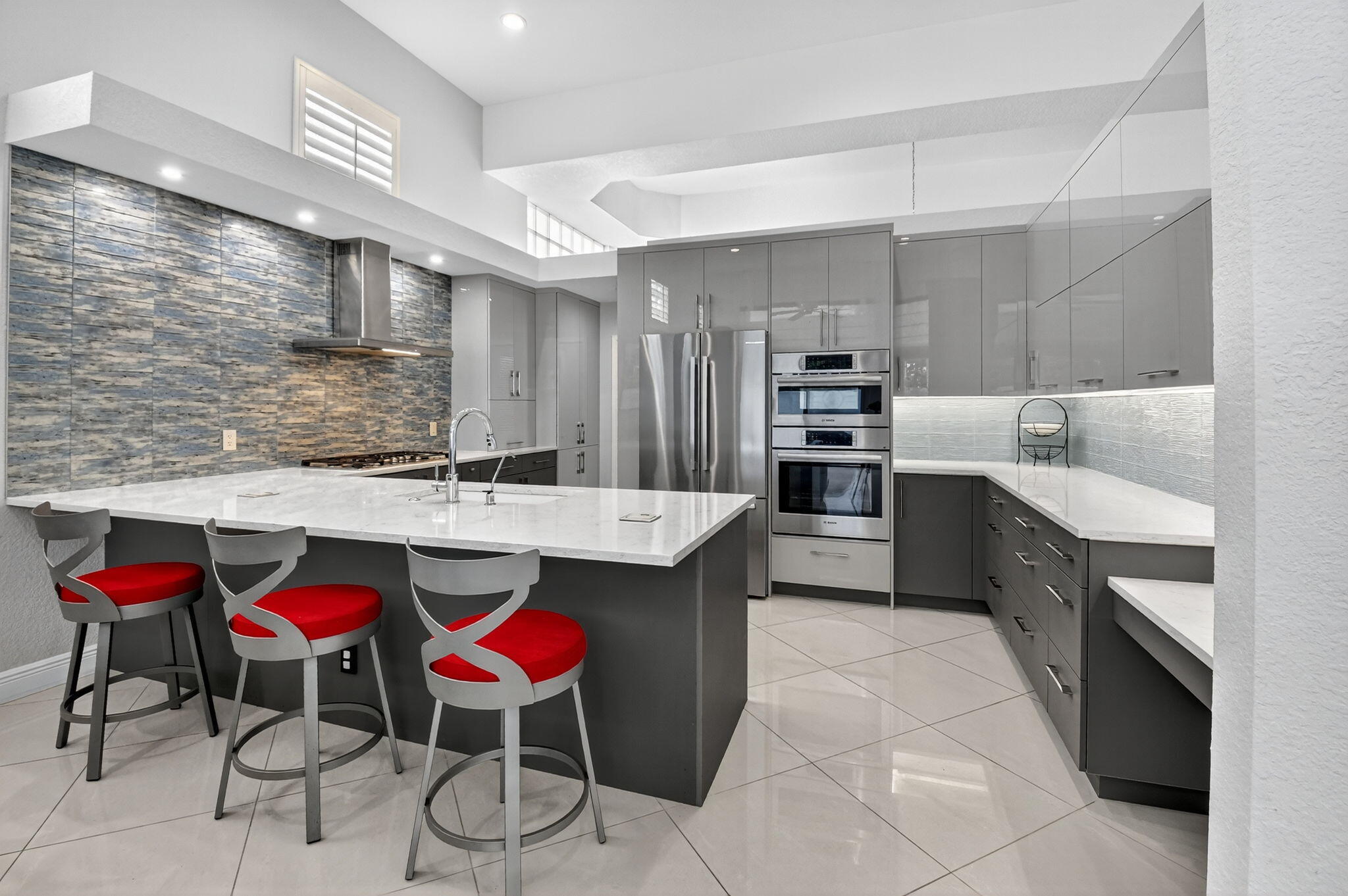 6535 Somerset Circle Boca Raton, FL 33496 - Photo 16 of 59 a kitchen with stainless steel appliances kitchen island granite countertop a table chairs sink and cabinets