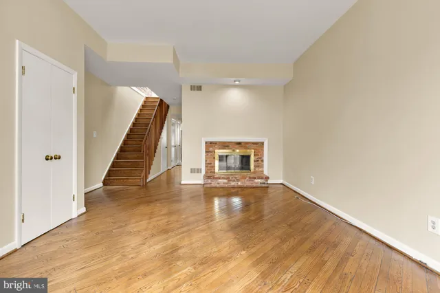 a view of a livingroom with wooden floor and stairs