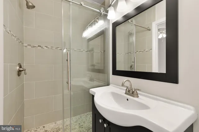 a bathroom with a sink a mirror and shower