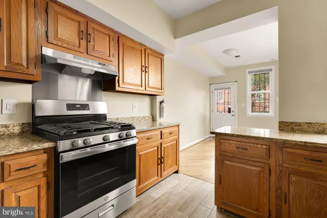 a kitchen with stainless steel appliances granite countertop a stove and a sink