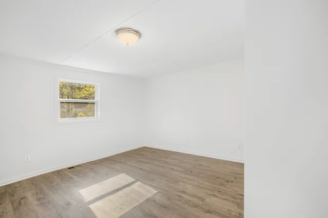 a view of a room with wooden floor and window