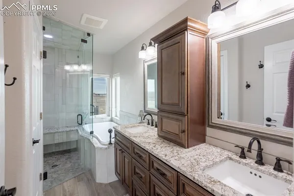 a bathroom with a granite countertop sink double vanity and a mirror