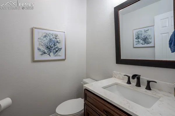 a bathroom with a granite countertop toilet sink and mirror