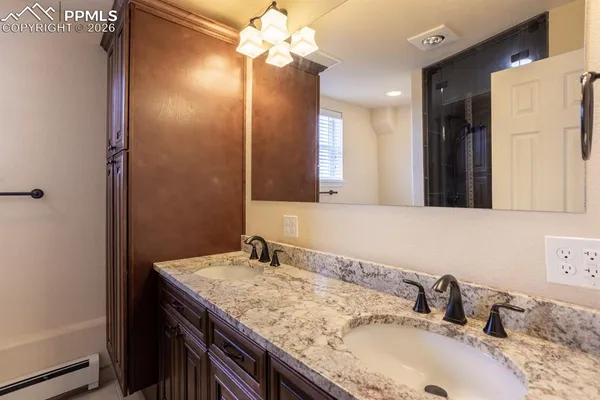 a bathroom with a granite countertop sink a large mirror and a shower