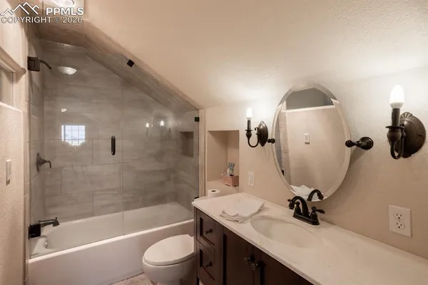 a bathroom with a granite countertop sink a toilet and bathtub