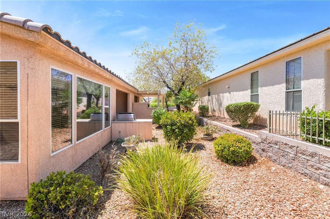 5389 Progresso Street Las Vegas, NV 89135 - Photo 30 of 41 A private, landscaped courtyard connects two buildings under a bright sky.