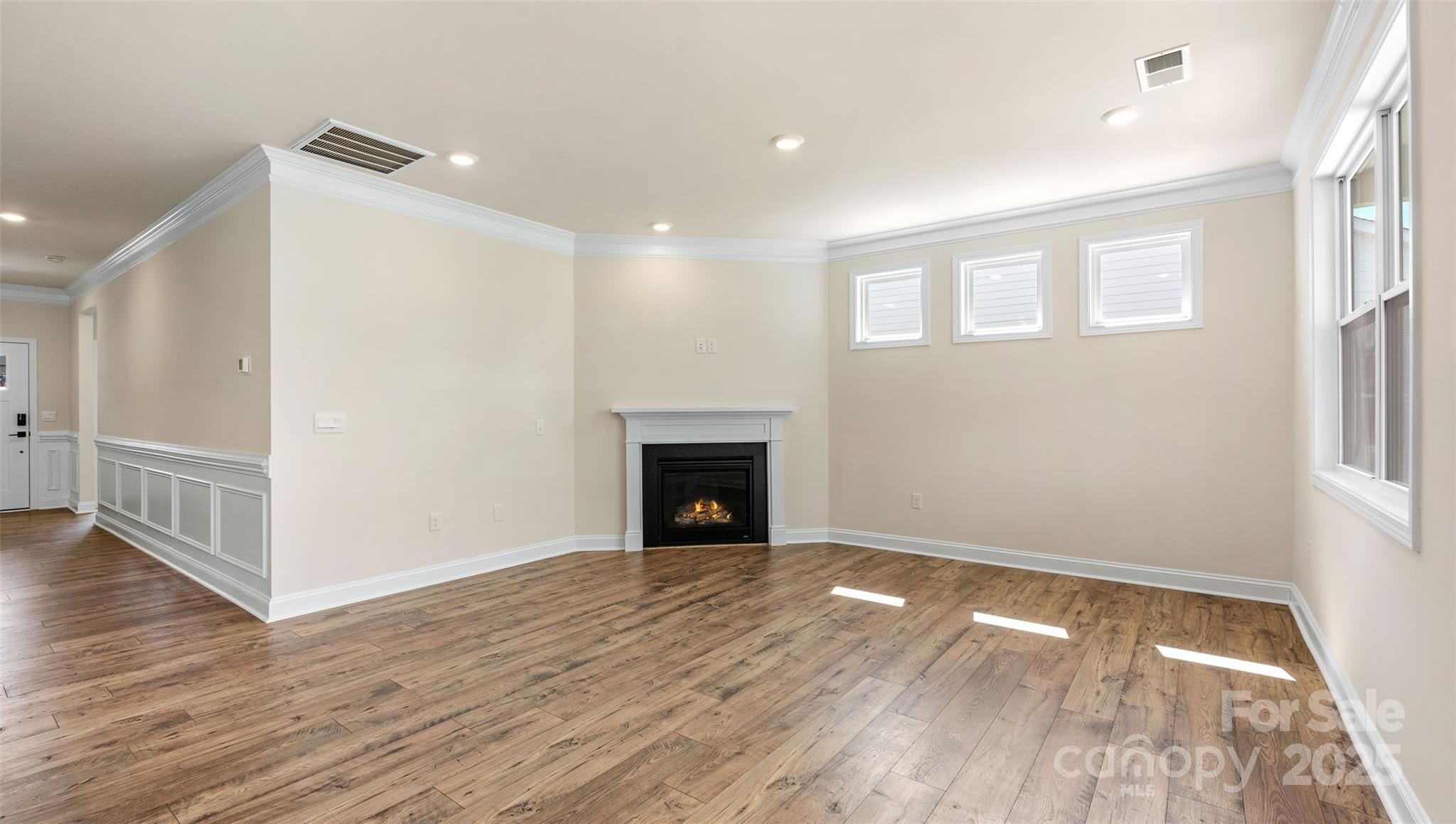 610 River Btm Road Fletcher, NC 28732 - Photo 9 of 28 an empty room with wooden floor and fireplace