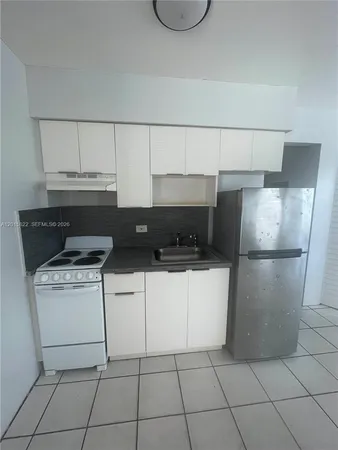 a kitchen with a stove top oven and cabinets
