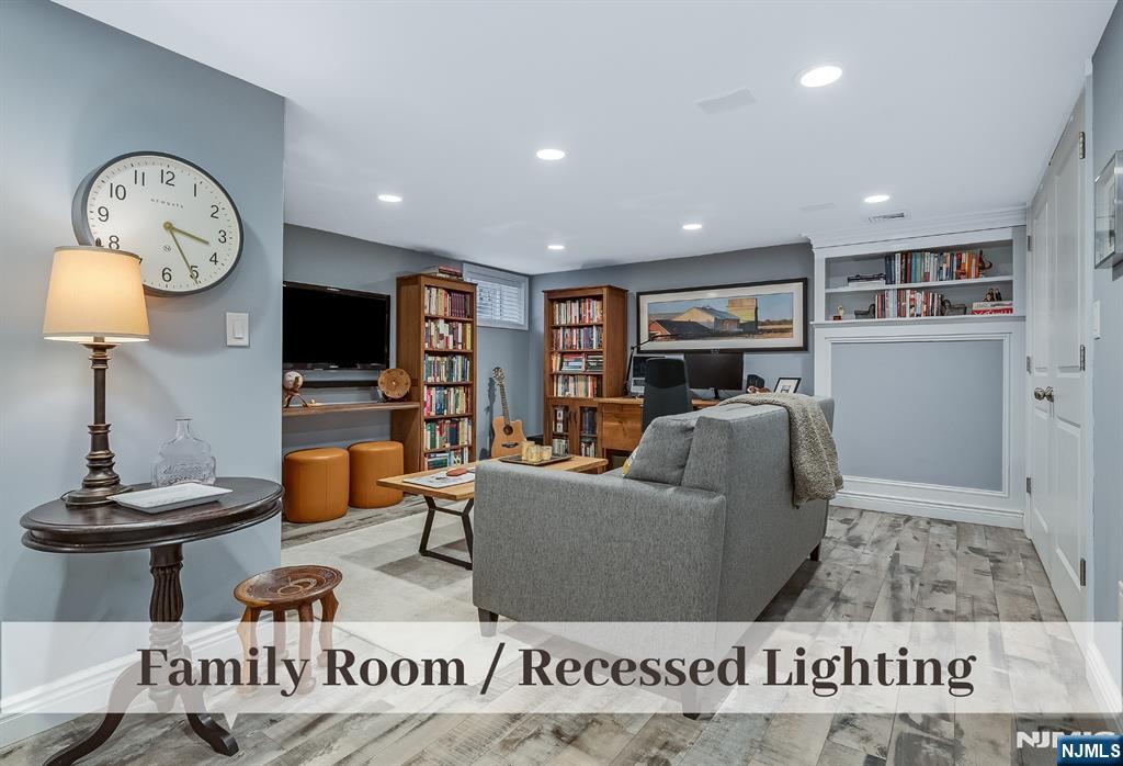 446 Upper Boulevard Ridgewood, NJ 07450 - Photo 32 of 48 a living room with furniture a clock and a flat screen tv