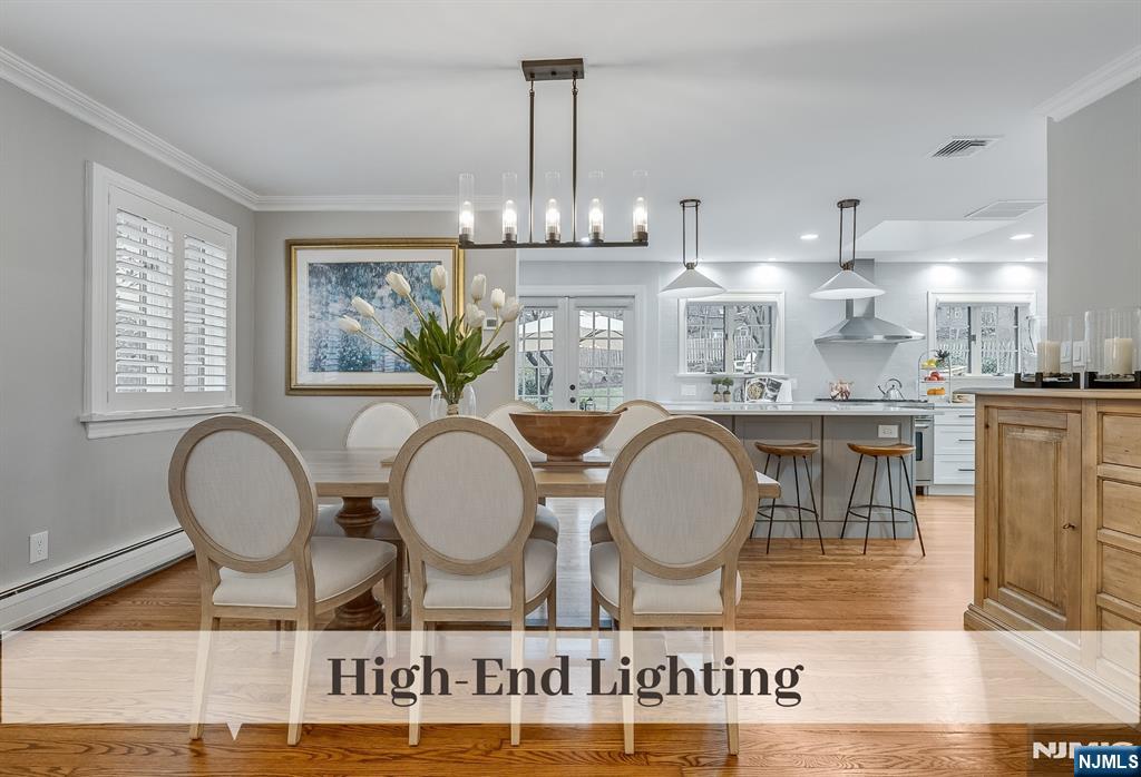 446 Upper Boulevard Ridgewood, NJ 07450 - Photo 10 of 48 a kitchen with kitchen island granite countertop a stove a sink and a dining table with wooden floor