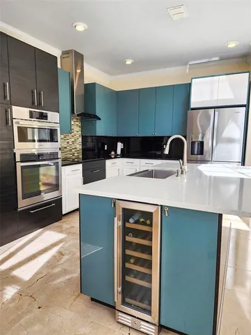 a kitchen with stainless steel appliances a stove a refrigerator and a sink with wooden cabinets