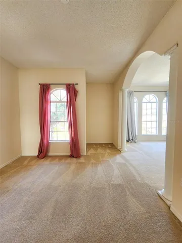 an empty room with a fireplace and windows