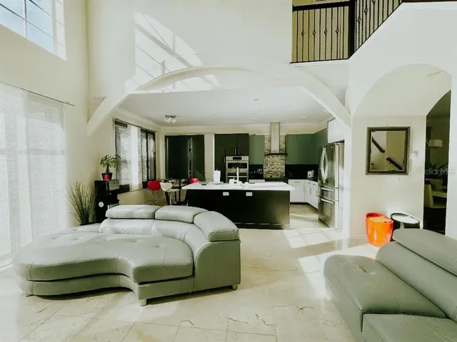 a living room with a couch kitchen view and a large window