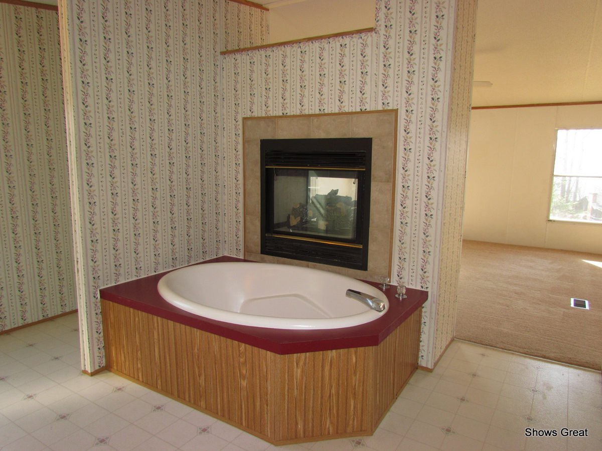 4714 Wade Road Roanoke, VA 24018 - Photo 5 of 16 a bath tub sitting in a bathroom next to a window