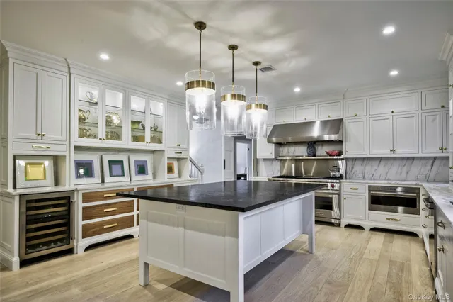 a kitchen with stainless steel appliances granite countertop a sink a stove and a wooden floors