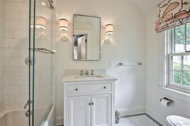 a bathroom with a sink a toilet and shower