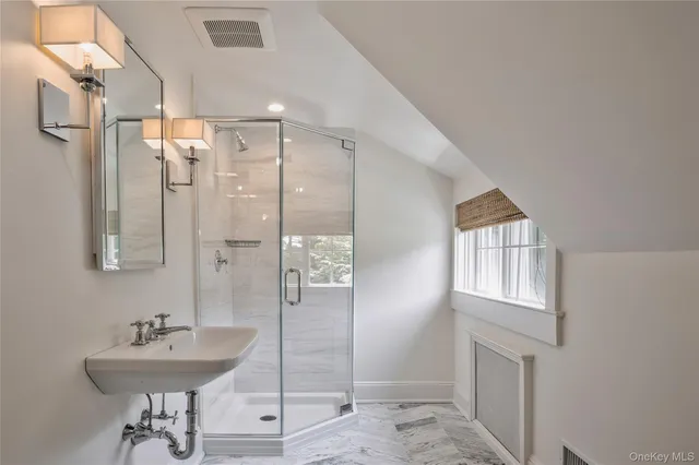 a bathroom with a sink shower and a mirror