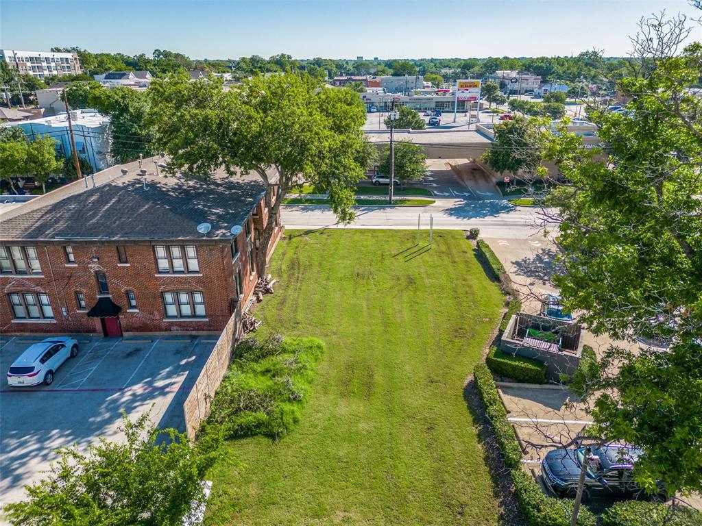 an aerial view of a house with swimming pool and large trees
