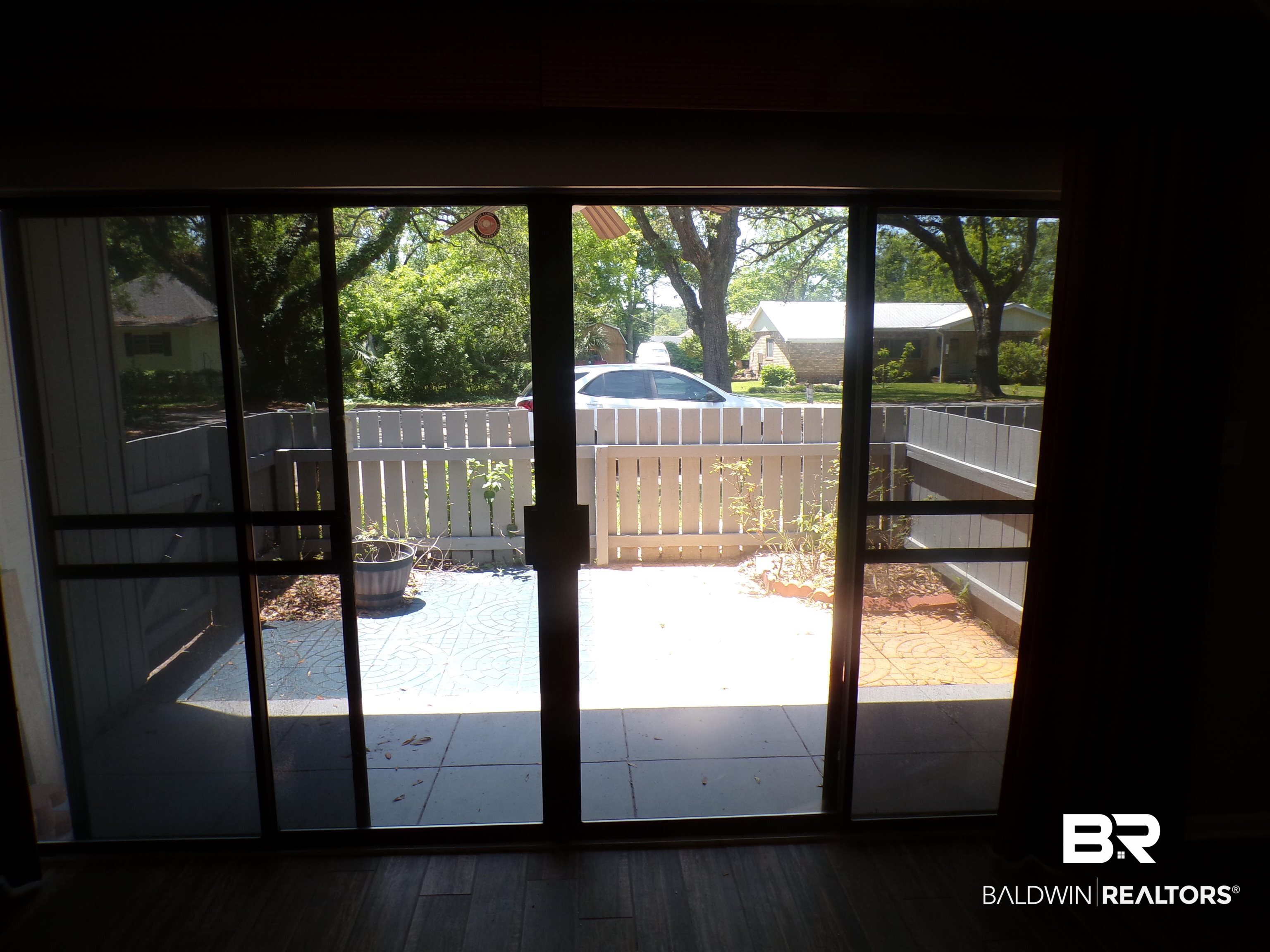 1152 North Alston Street, Unit 1152 Foley, AL 36535 - Photo 9 of 16 Sliding glass doors opening to a private patio space with a white privacy fence