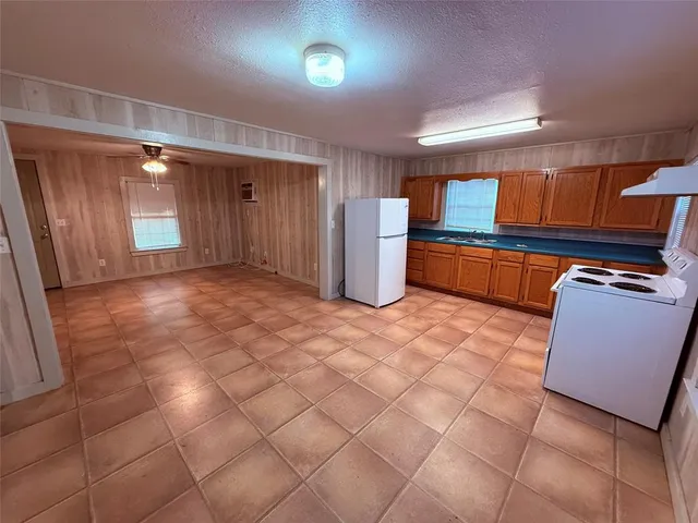 a big room with chandelier fan and windows
