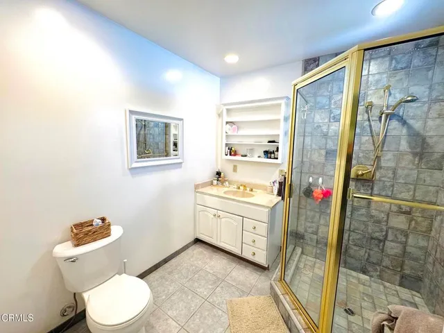 a bathroom with a granite countertop sink mirror vanity and toilet